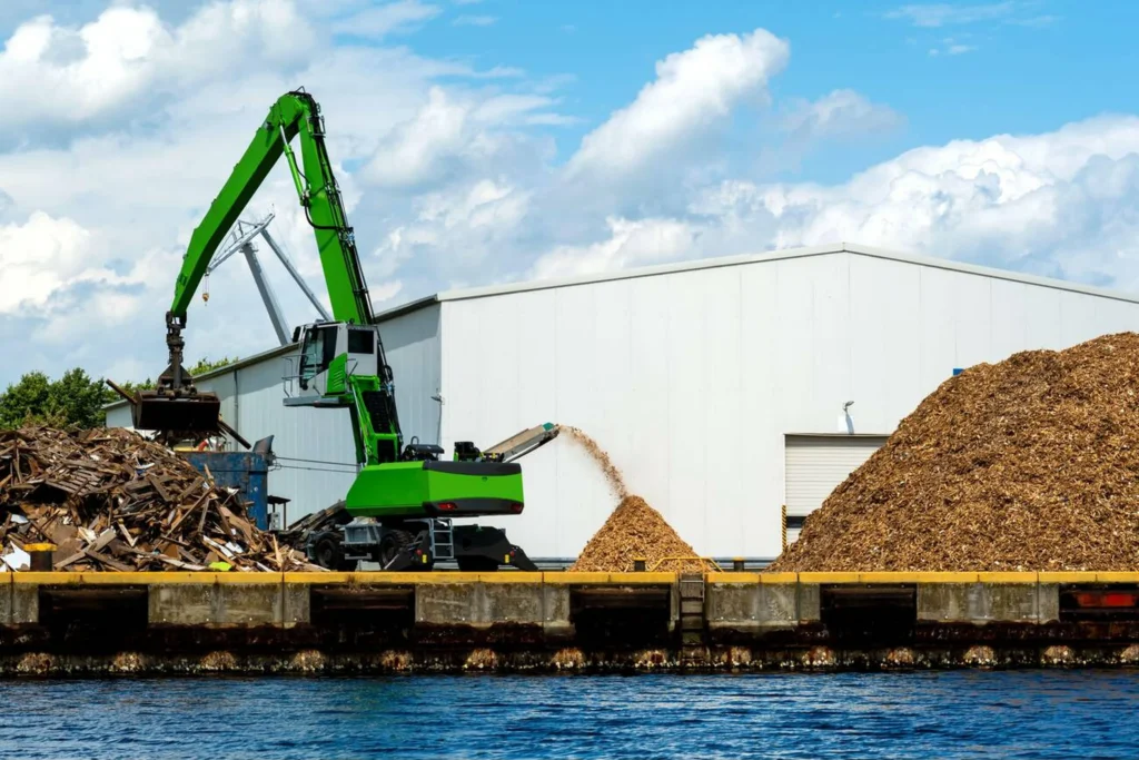 Maquinaria triturando madera reciclada en planta industrial para su reutilización